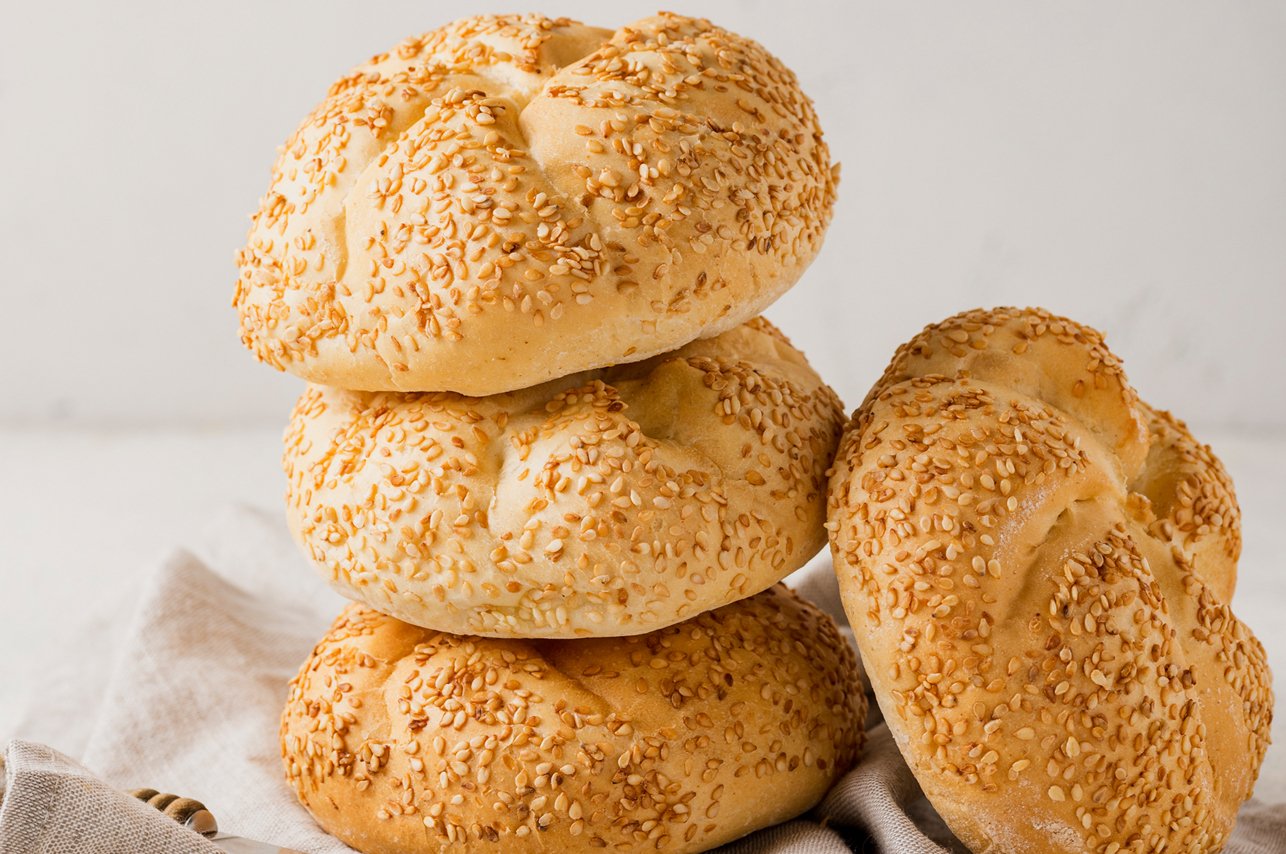 Bunch of fresh carrots with green leaves over wooden background