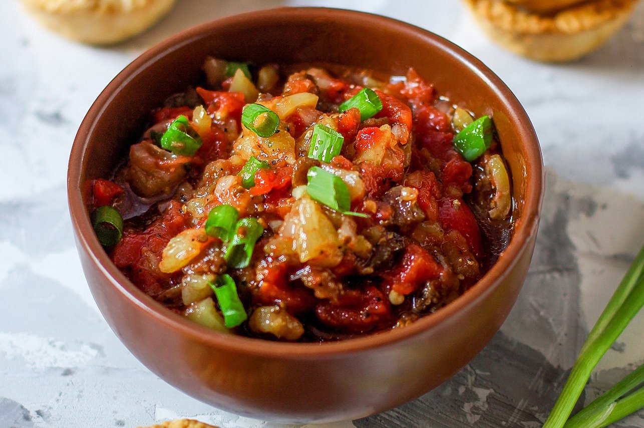 Bunch of fresh carrots with green leaves over wooden background