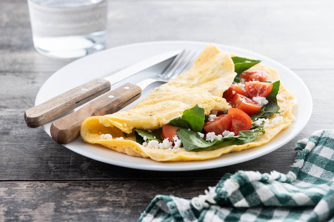 Bunch of fresh carrots with green leaves over wooden background