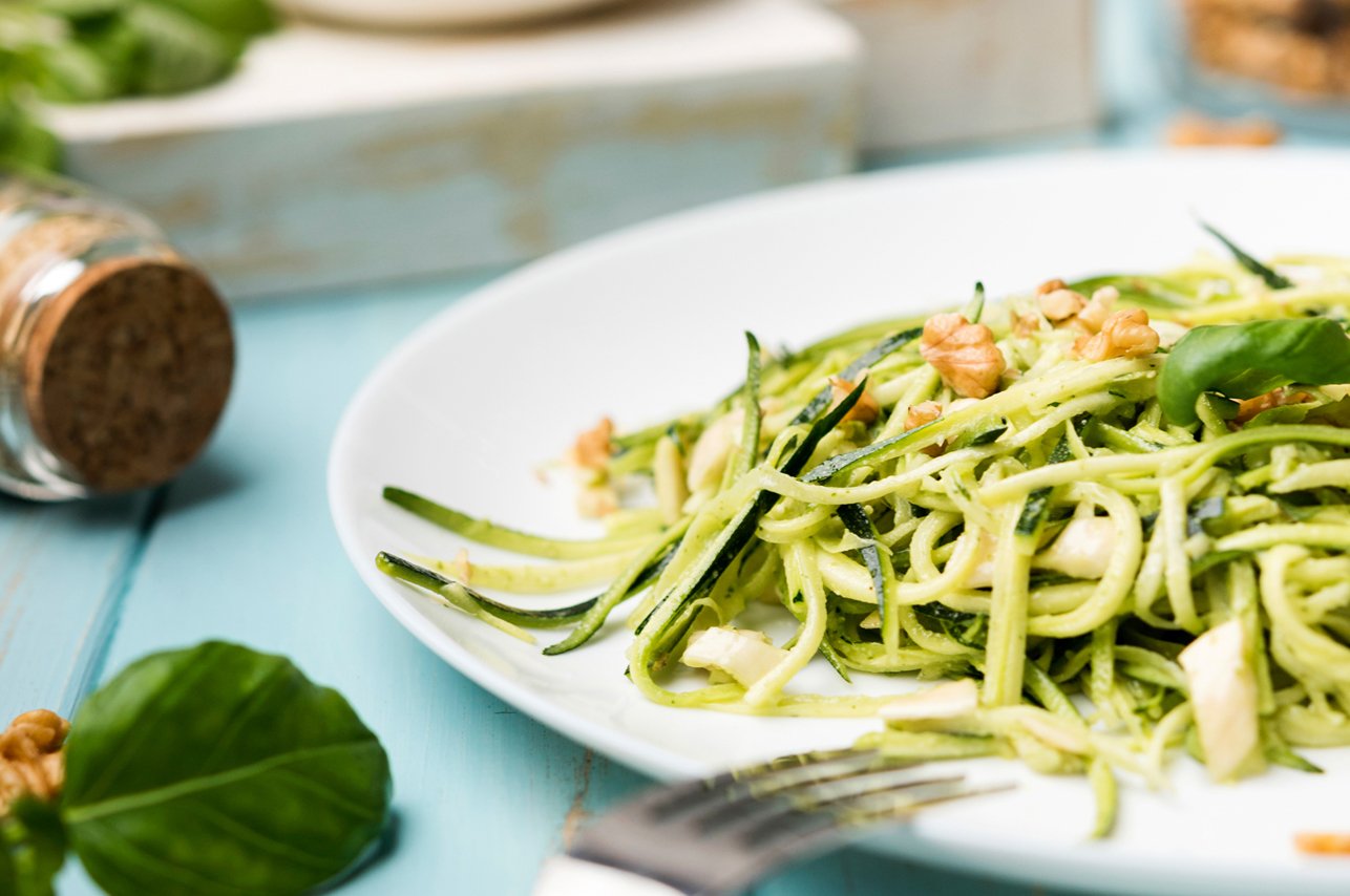 Bunch of fresh carrots with green leaves over wooden background